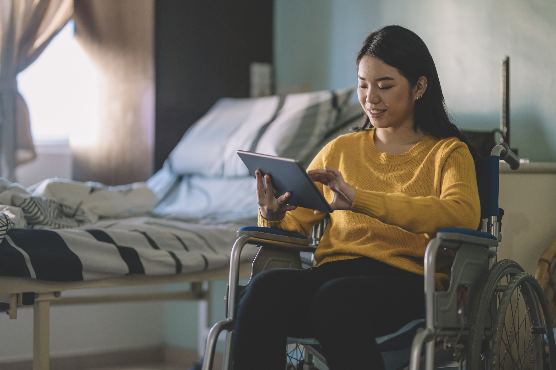 Girl in wheelchair looking at tablet