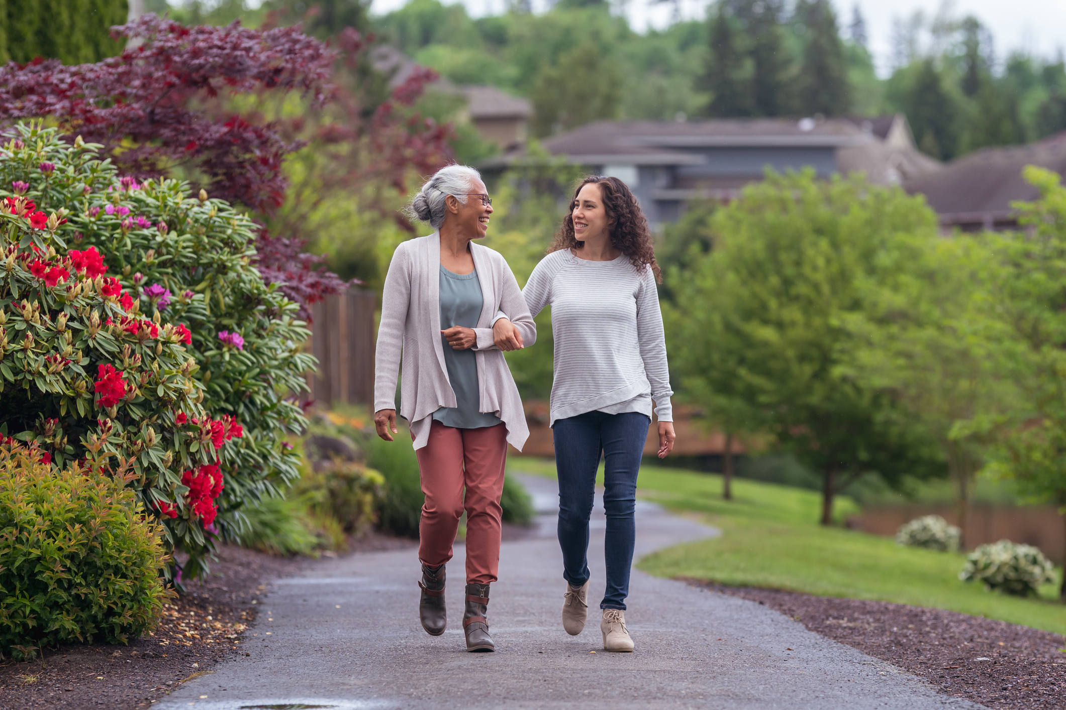 Older lady walking arm in arm with younger lady