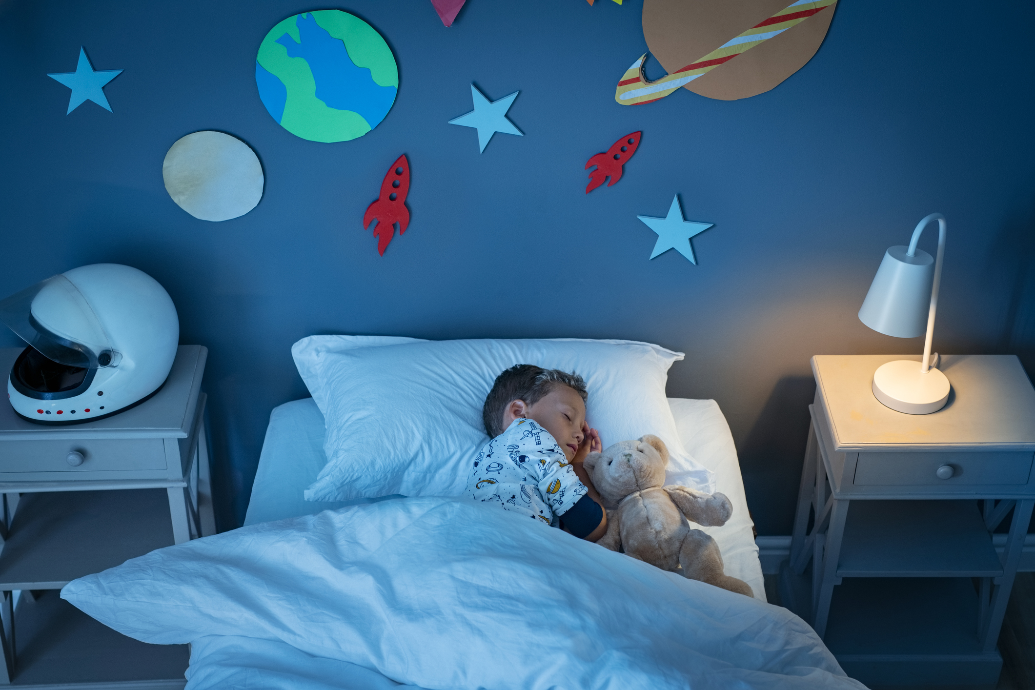Boy sleeping in space themed room