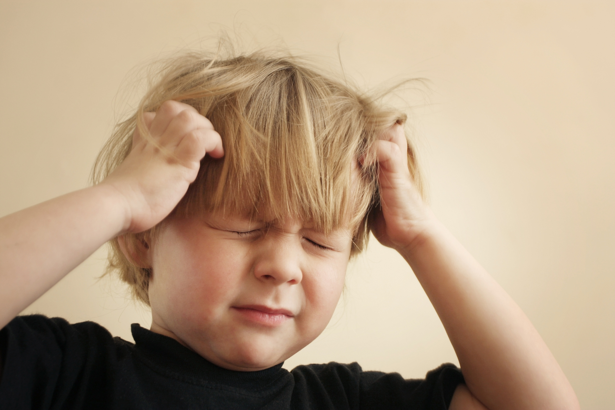 Boy holding his head in pain