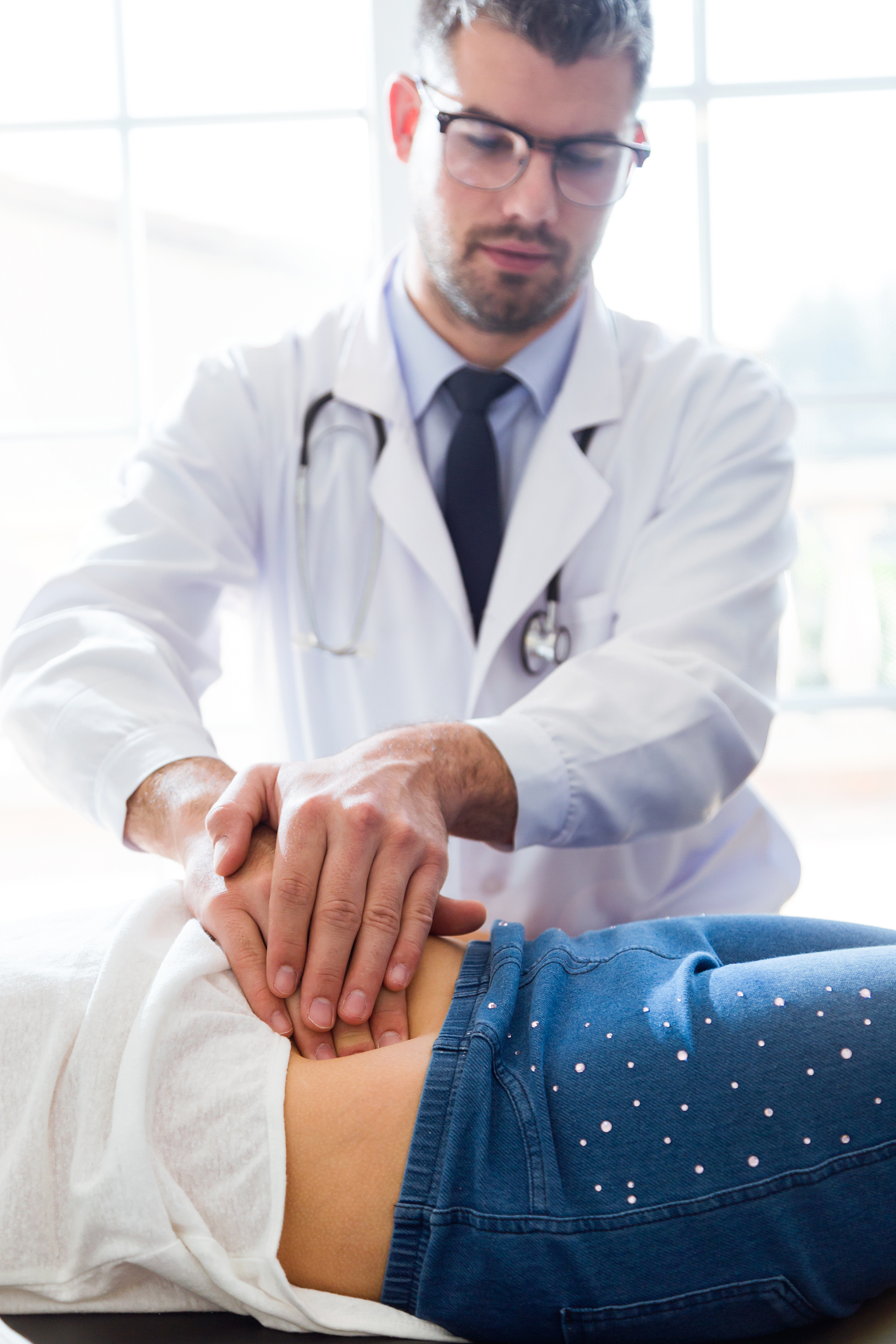 Doctor examining girl's stomach