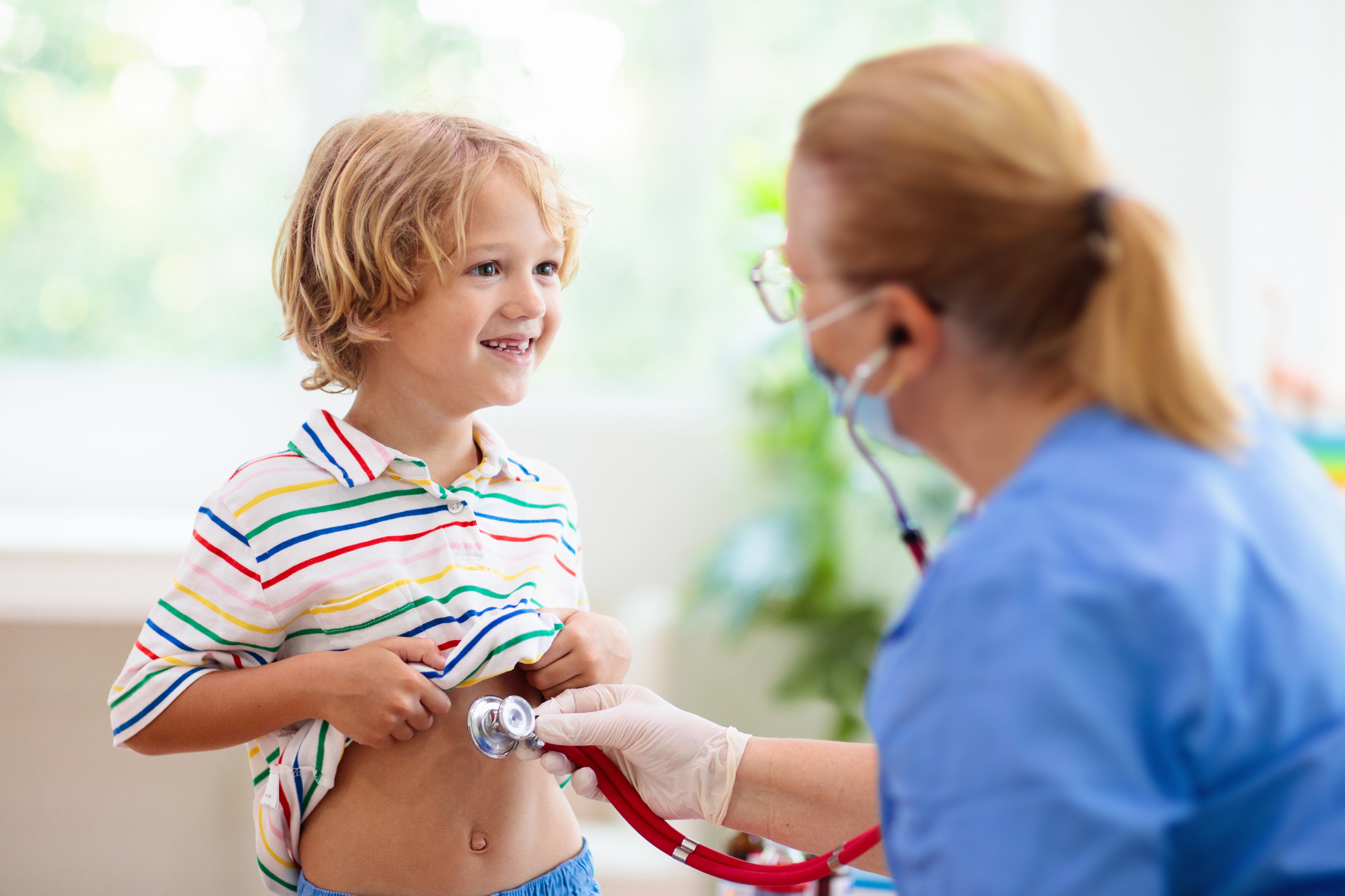 Doctor listening to young boy's stomach