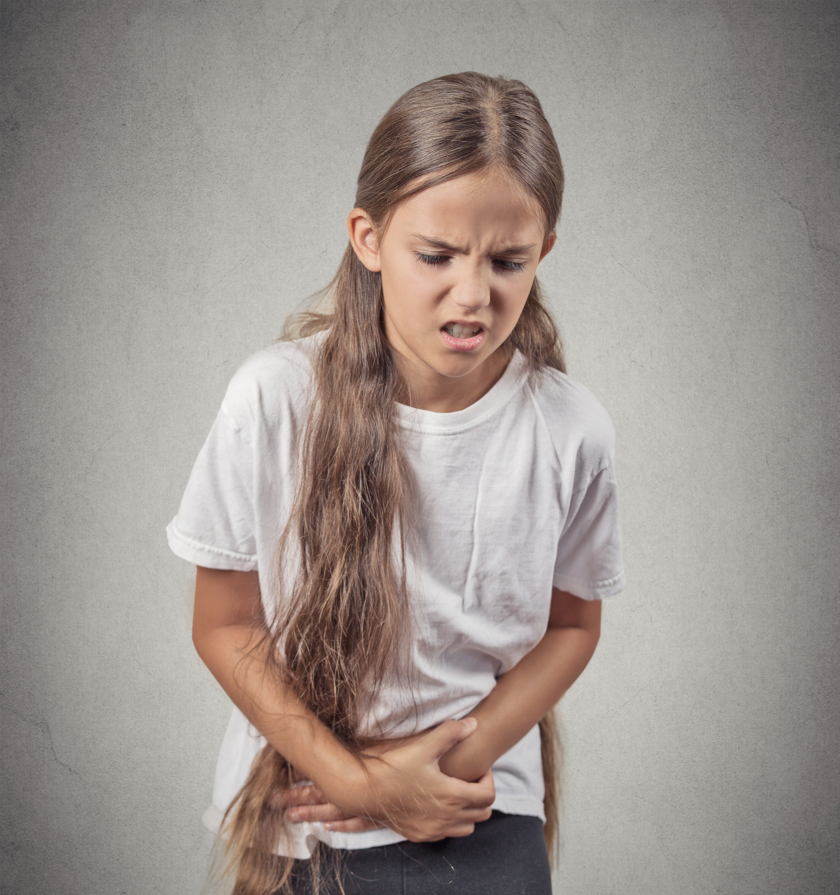 Teenage girl holding stomach in pain