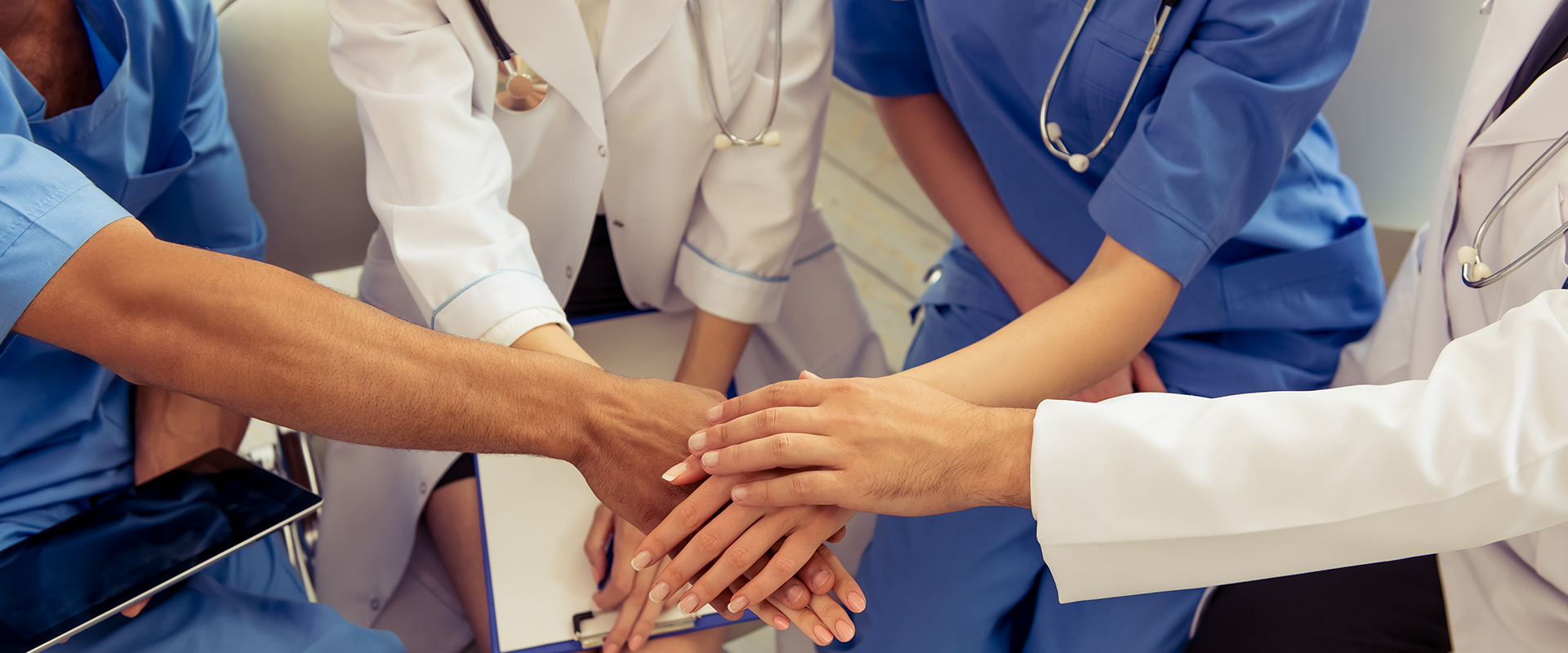 Group of medical providers with hands in middle of a circle