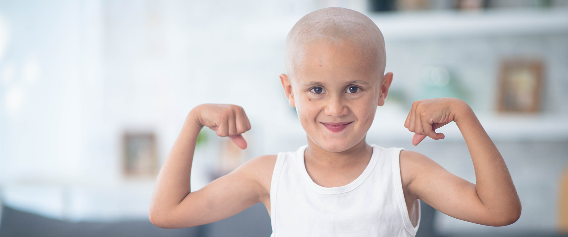 Boy with shaved hair showing off his muscles