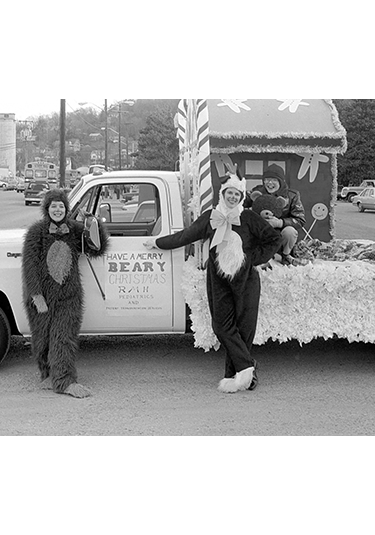 two people in bear costumes standing in front of float