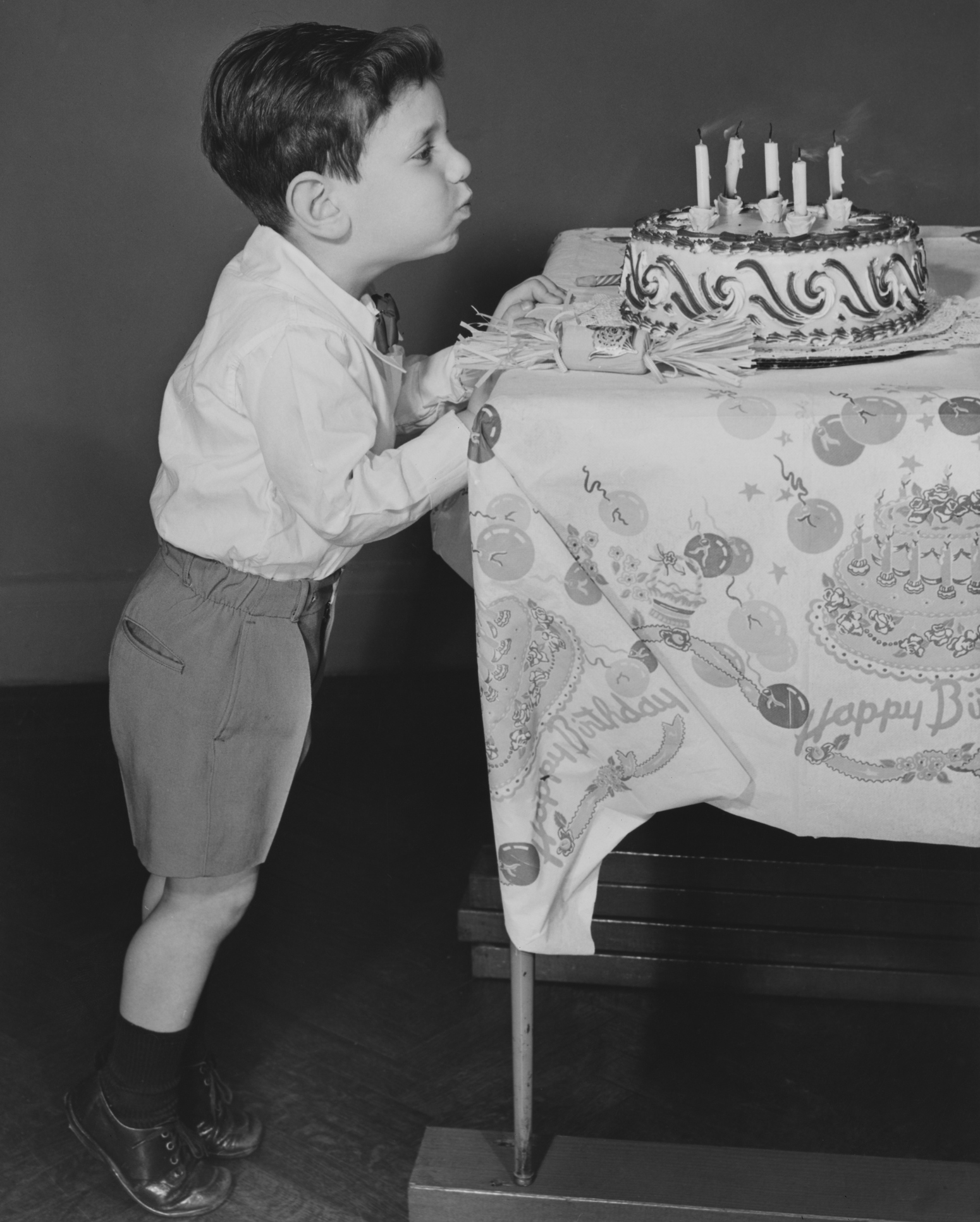 photo of boy blowing out candles - circa 1950