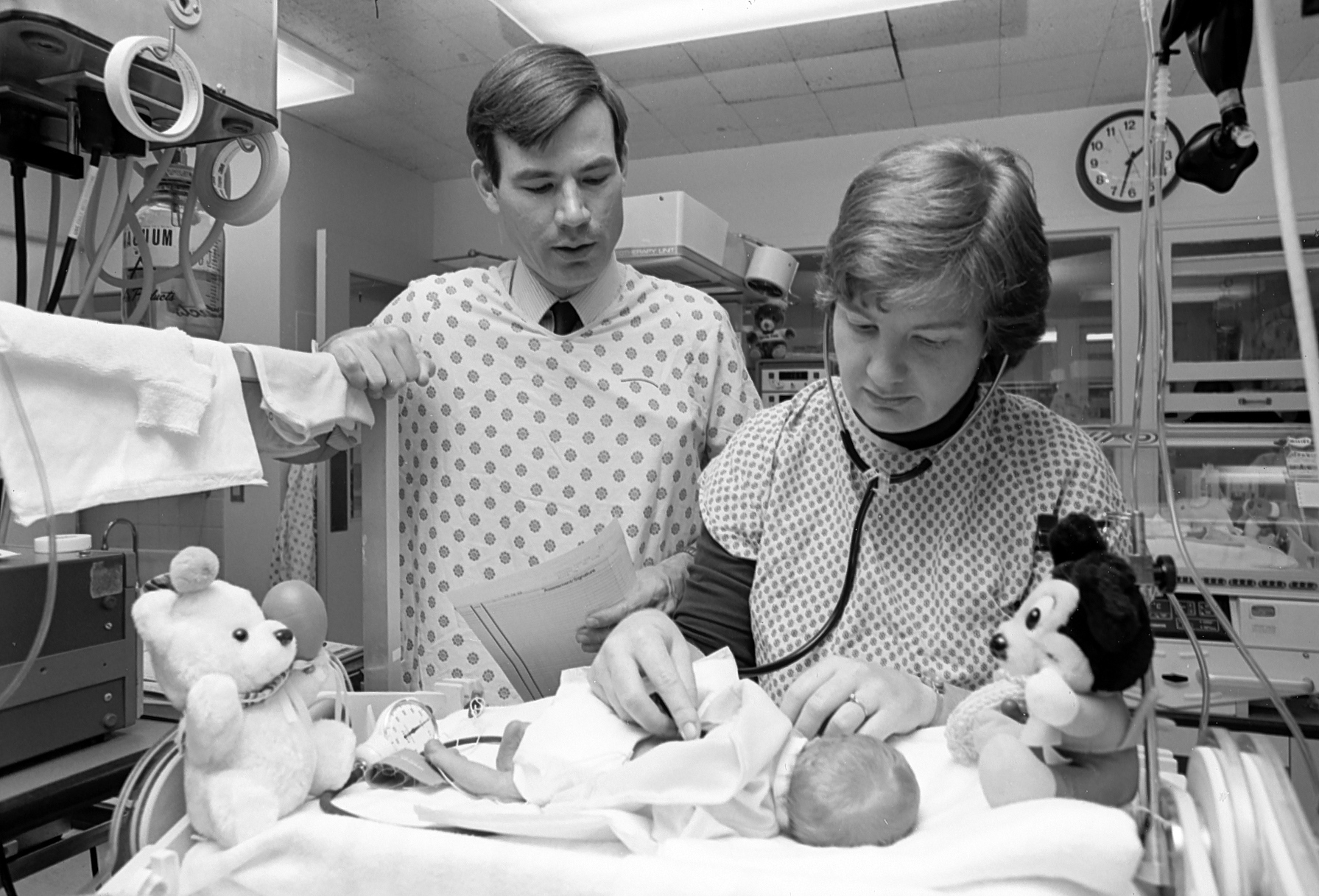A doctor and nurse examine an infant in the neonatal intensive care unit