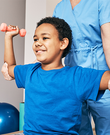 Smiling child with hands up, using dumbbells
