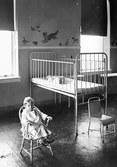 Child sitting in the Children's nursery circa late 1920s