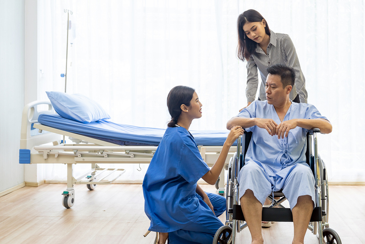 doctor talking to a patient in a wheelchair