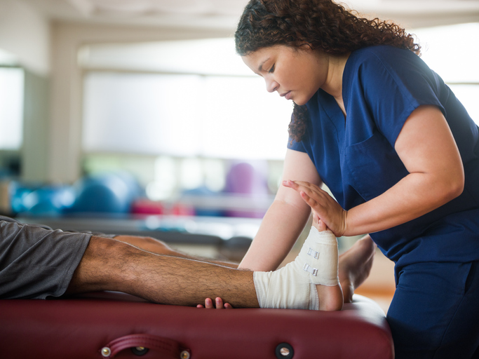 a nurse stretching a patient's foot