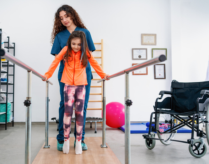 a child in physical therapy walking with a nurse