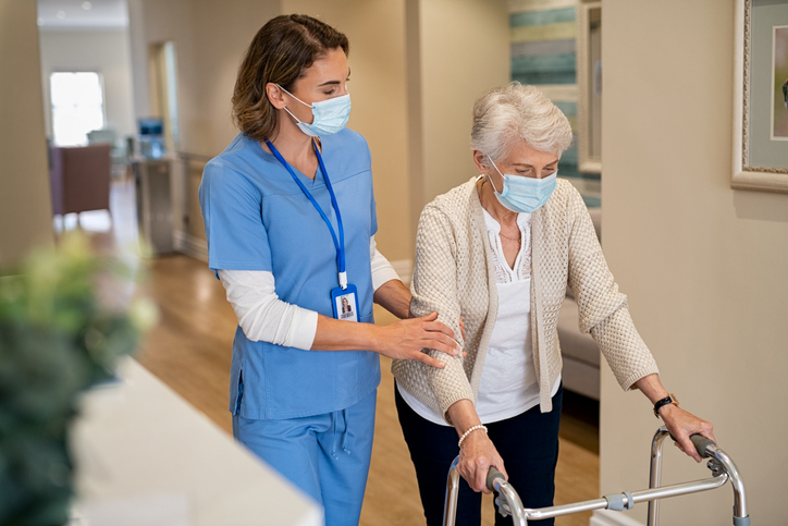 a nurse walking with a patient down the hall