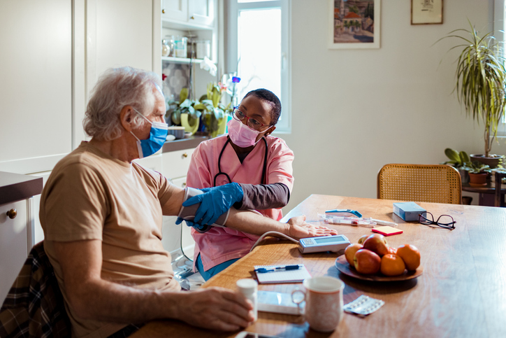 a nurse checking a patient's blood pressure