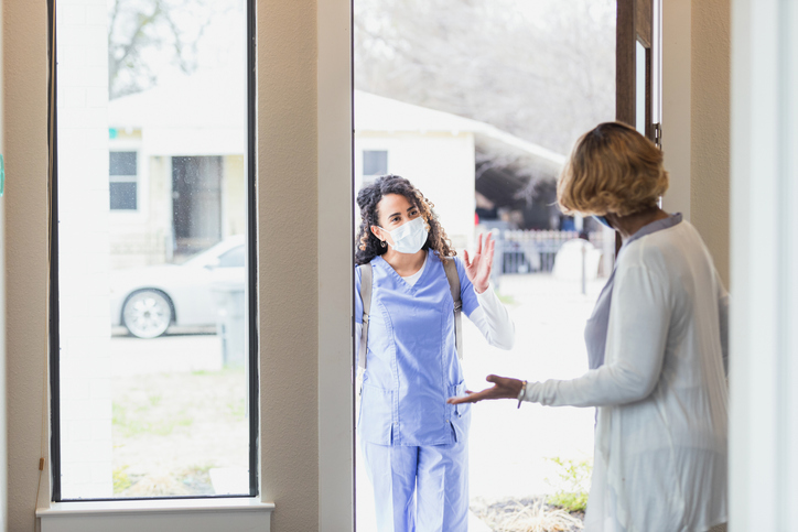 a woman inviting a nurse inside the house