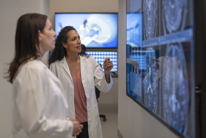 doctors looking at a brain scan on a screen