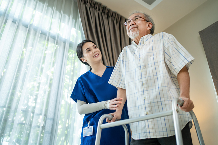 a nurse helping a patient with a walker walk
