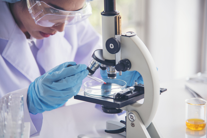 a doctor putting a sample under a microscope