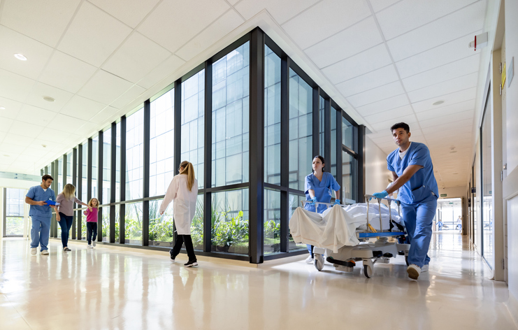 doctors pushing a patient in a medical bed down the hall