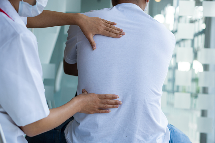 a doctor examining a patient's back