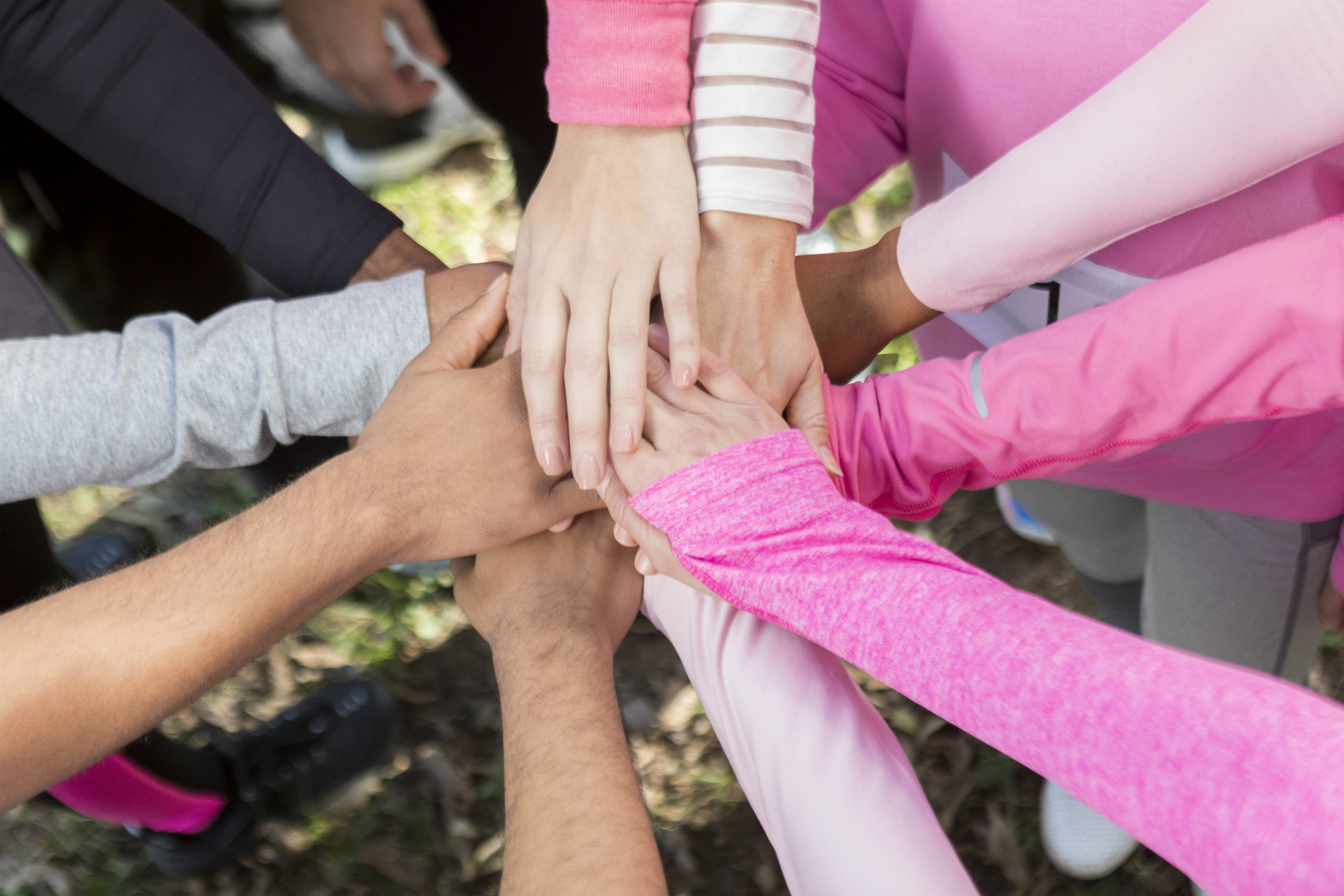 Various women put their hands on top of each other to show support.