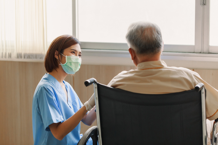 a nurse helping a man in wheelchair