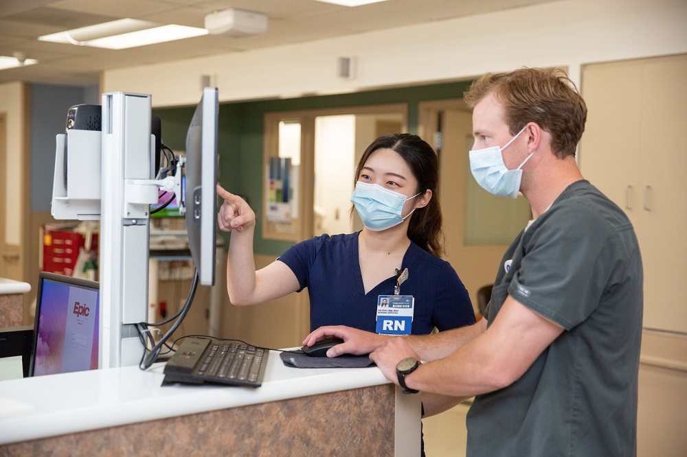Male and female nurse looking at a computer image