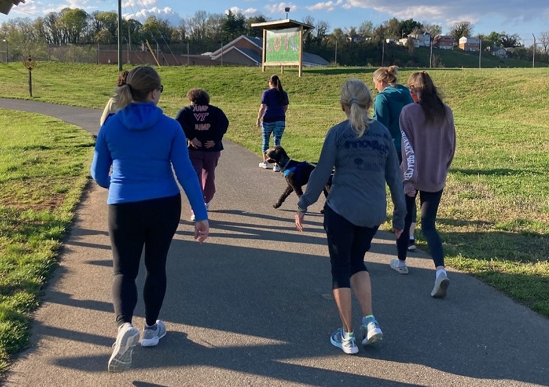 rear view of people walking on a paved greenway at Carilion Clinic wellness event