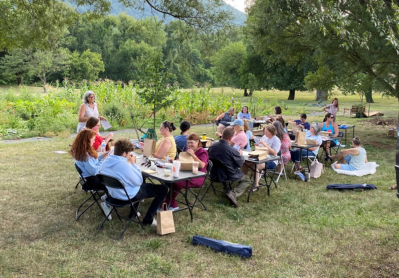 group of filled picnic tables where community members are enjoying stew at Carilion Clinic event