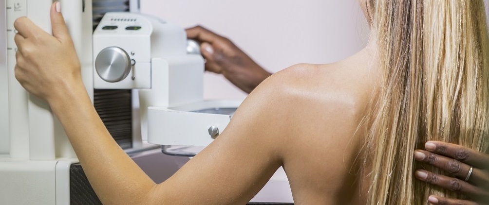 rear view of woman and radiologist at mammogram machine