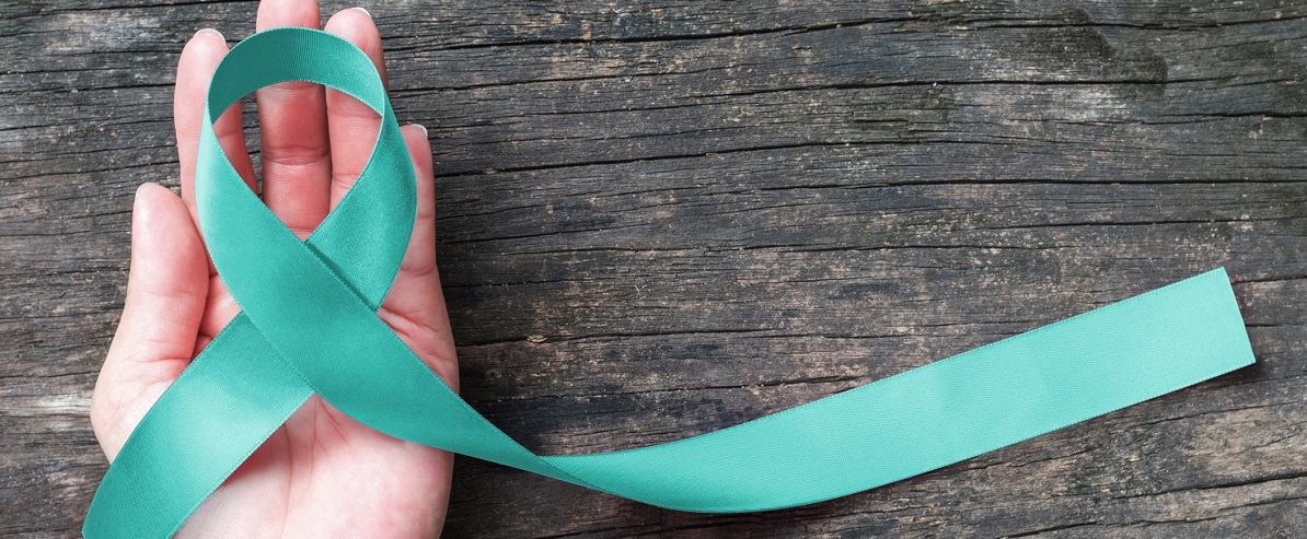 hand holding teal ribbon indicating ovarian cancer