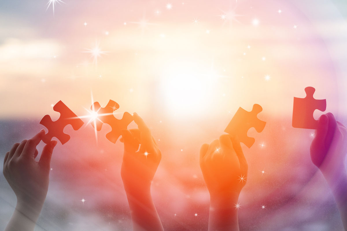 Hands of children holding pieces of jigsaw puzzle