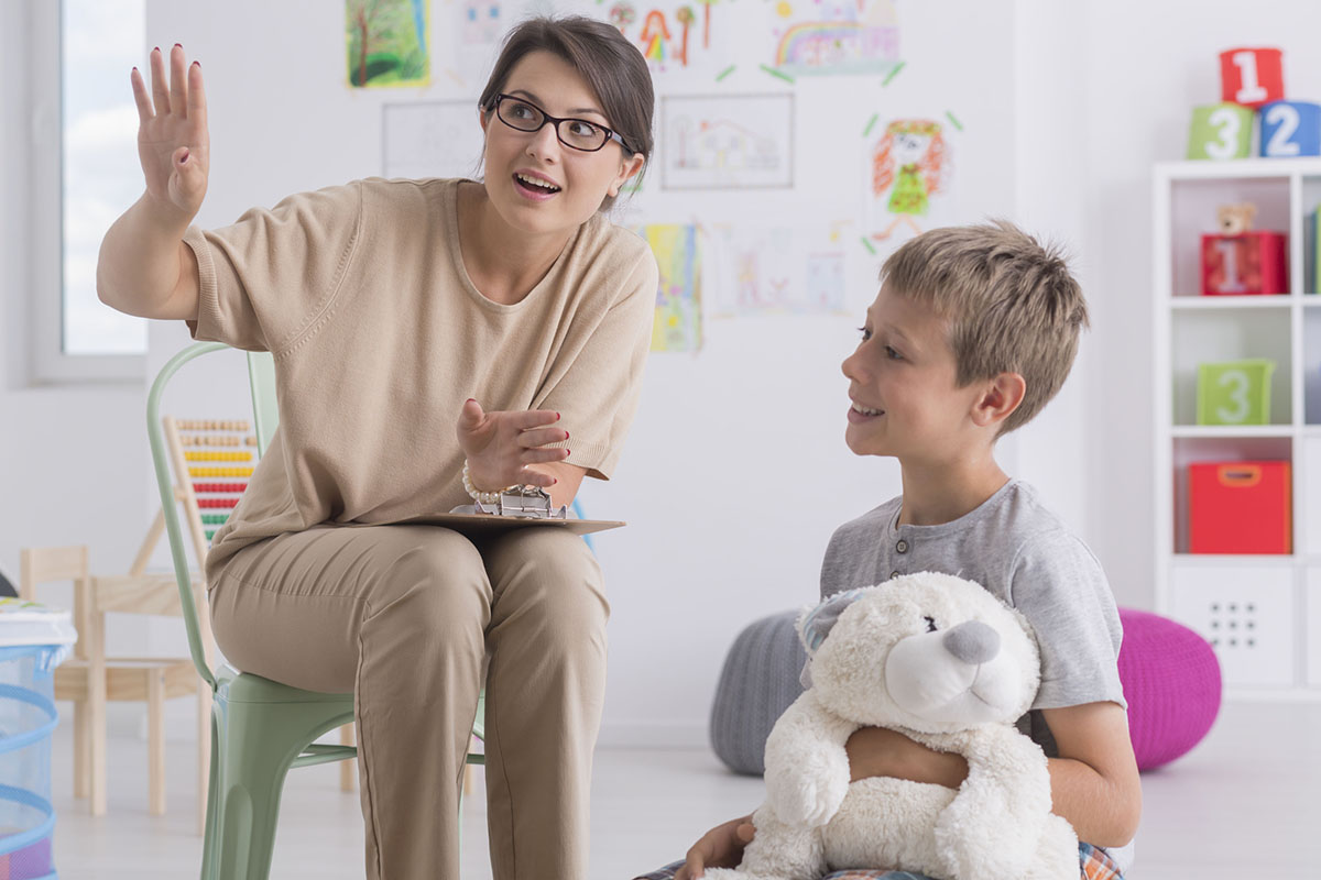 Boy holding teddy bear during visit at a psychotherapist