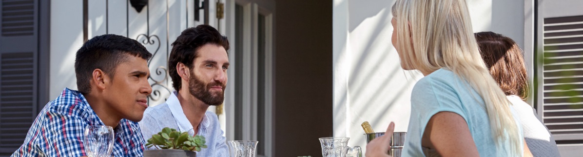 group of adults talking at outside restaurant table