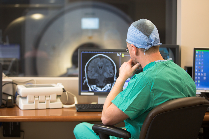 Dr. Witcher in front of brain image