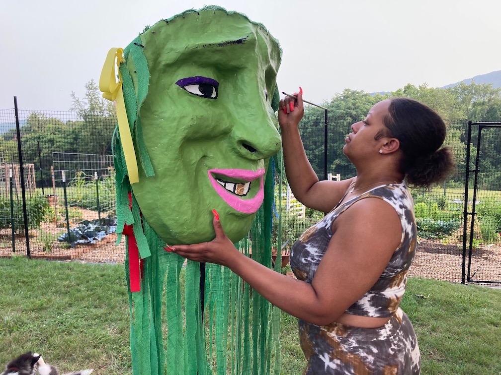 Woman painting a mask at Morningside Urban Farm