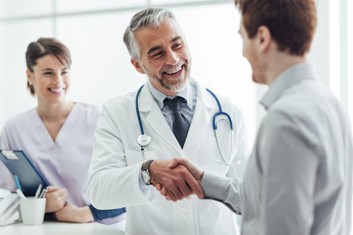 Healthcare provider shaking hands with patient image
