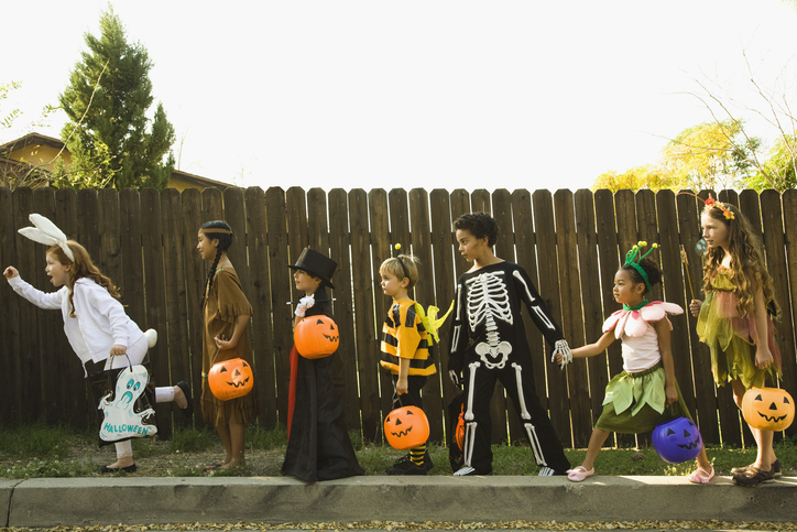 Children trick-or-treating on a sidewalk