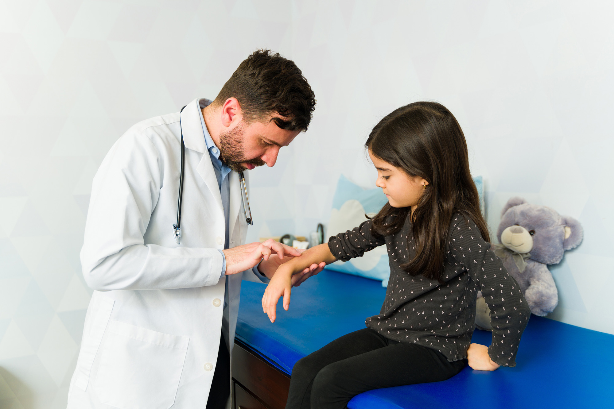 pediatric dermatologist examine a child's arm