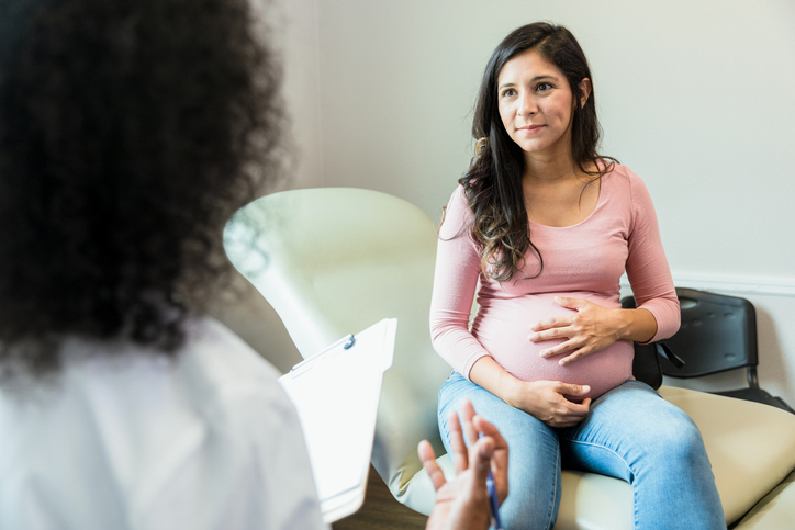 Pregnant woman speaking with a doctor