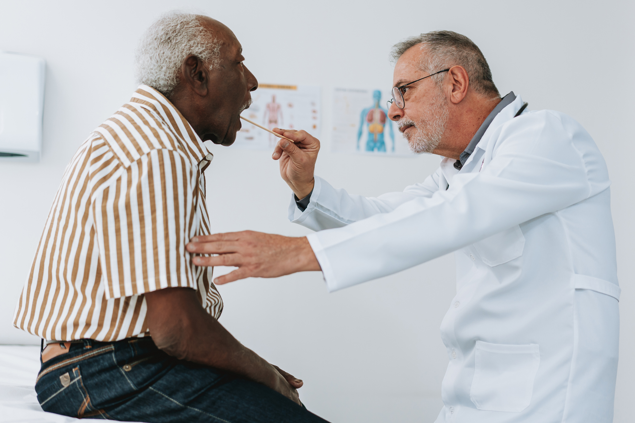 Doctor examining the throat of a patient.