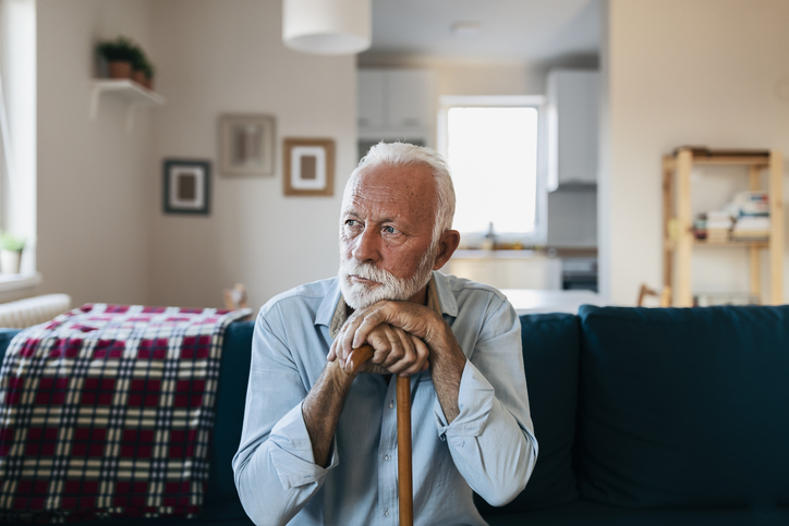 older man sitting by himself in his home