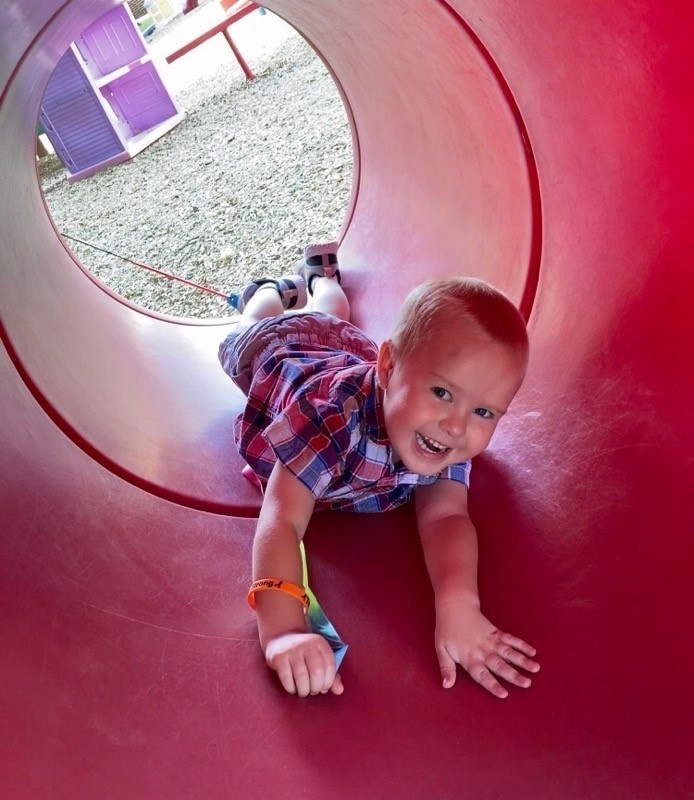 Tripp crawling through a playground tunnel