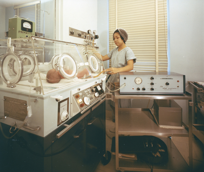Carilion Clinic history - a nurse checks on an infant on an Arp respirator, designed at Virginia Tech in collaboration with Carilion staff to reduce respiratory distress. 